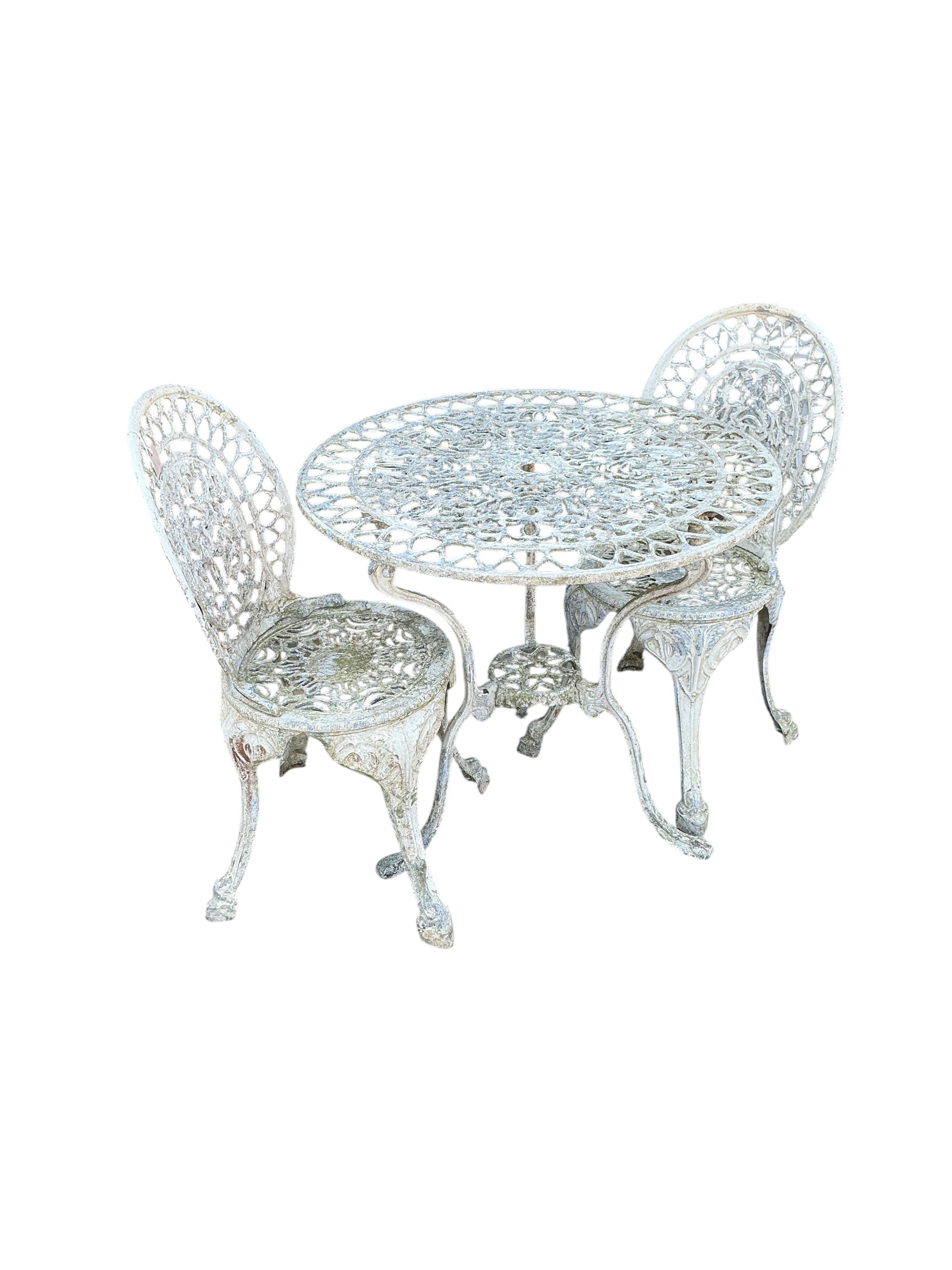 A Victorian style circular aluminium garden table, diameter 75cm, height 71cm and two similar chairs